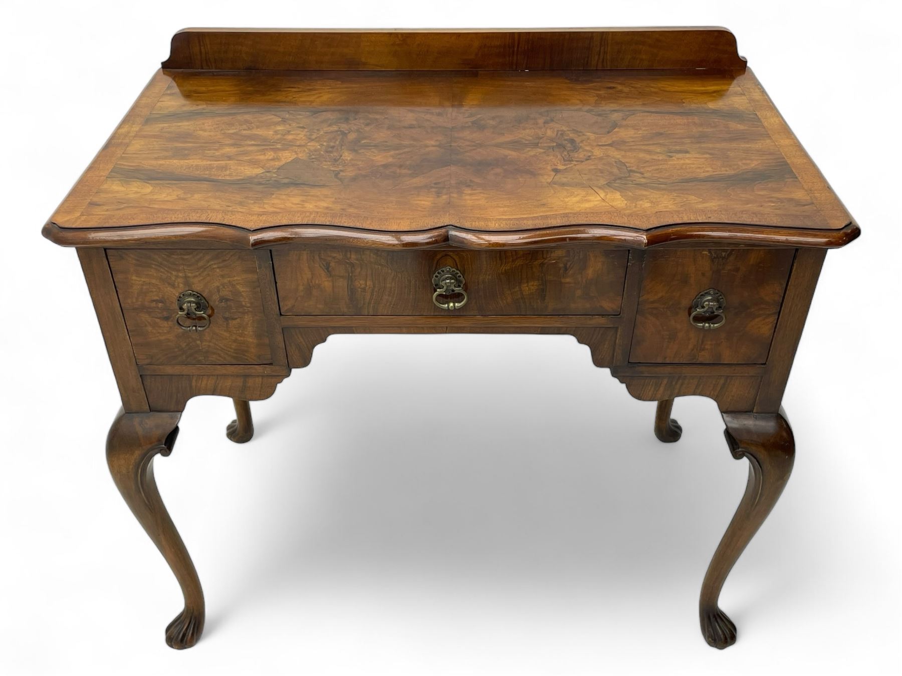 Mid-to-late 20th century figured walnut side table, raised back over figured top with cross banding and shaped front, fitted with three drawers, on cabriole supports with carved terminals 