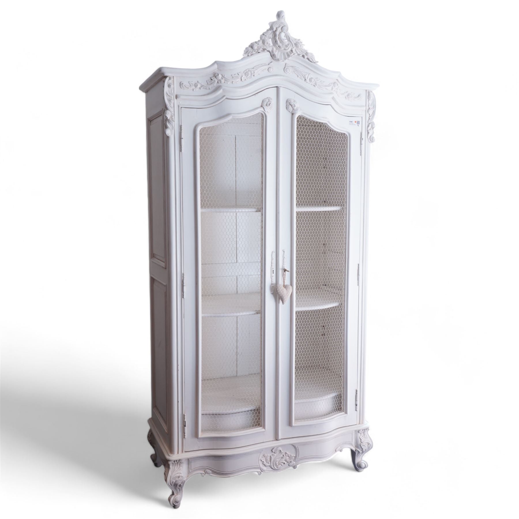 French design white painted and carved armoire, arched pediment with moulded scrolling foliate decoration, fitted with two wire-work doors enclosing three shelves, raised on acanthus carved cabriole feet