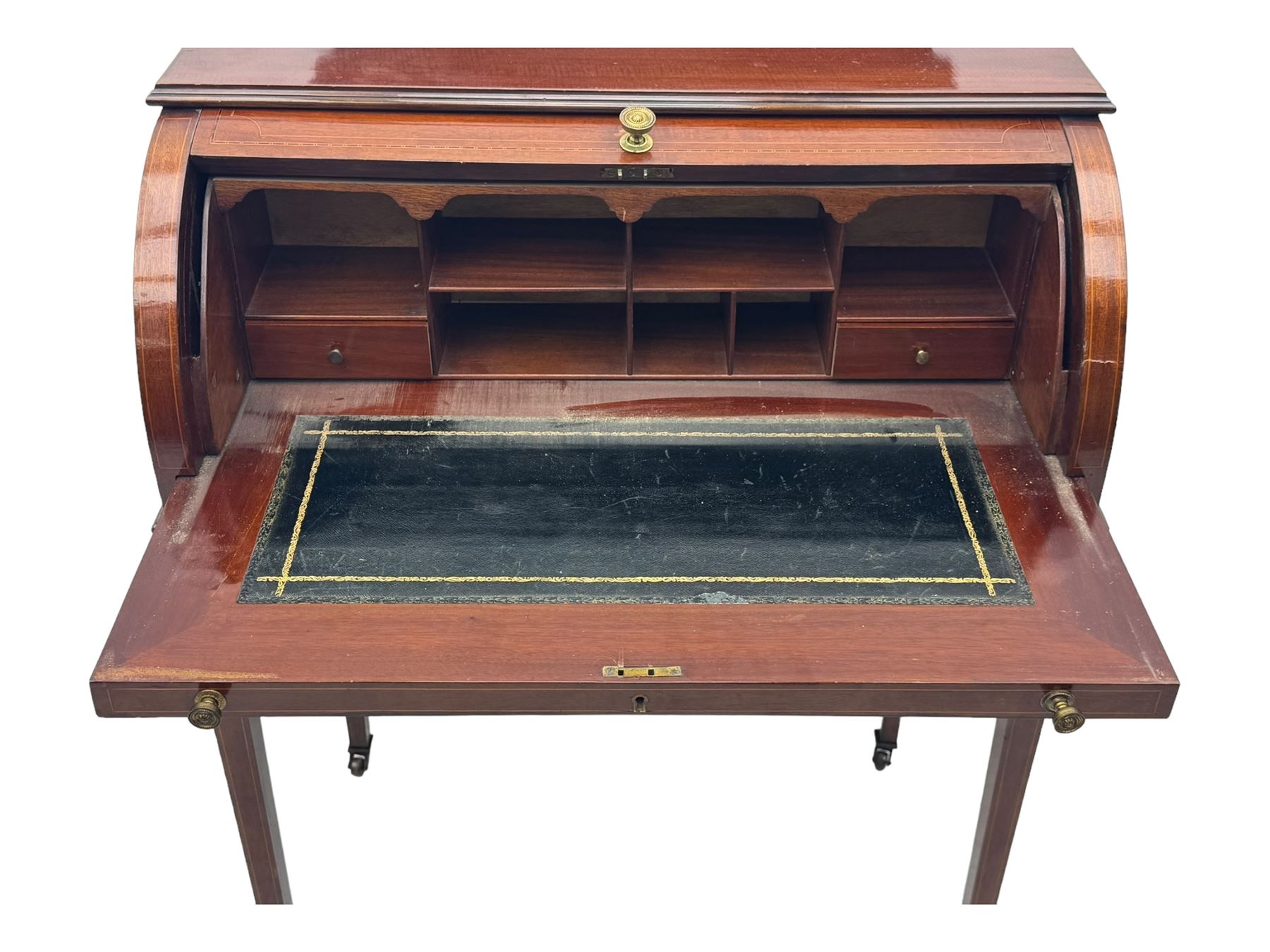 Edwardian inlaid mahogany roll-top desk, cylindrical lid enclosing fitted interior with pigeonholes, drawers and retractable writing surface, over two drawers with brass pull handles, on tapered supports with brass and ceramic castors