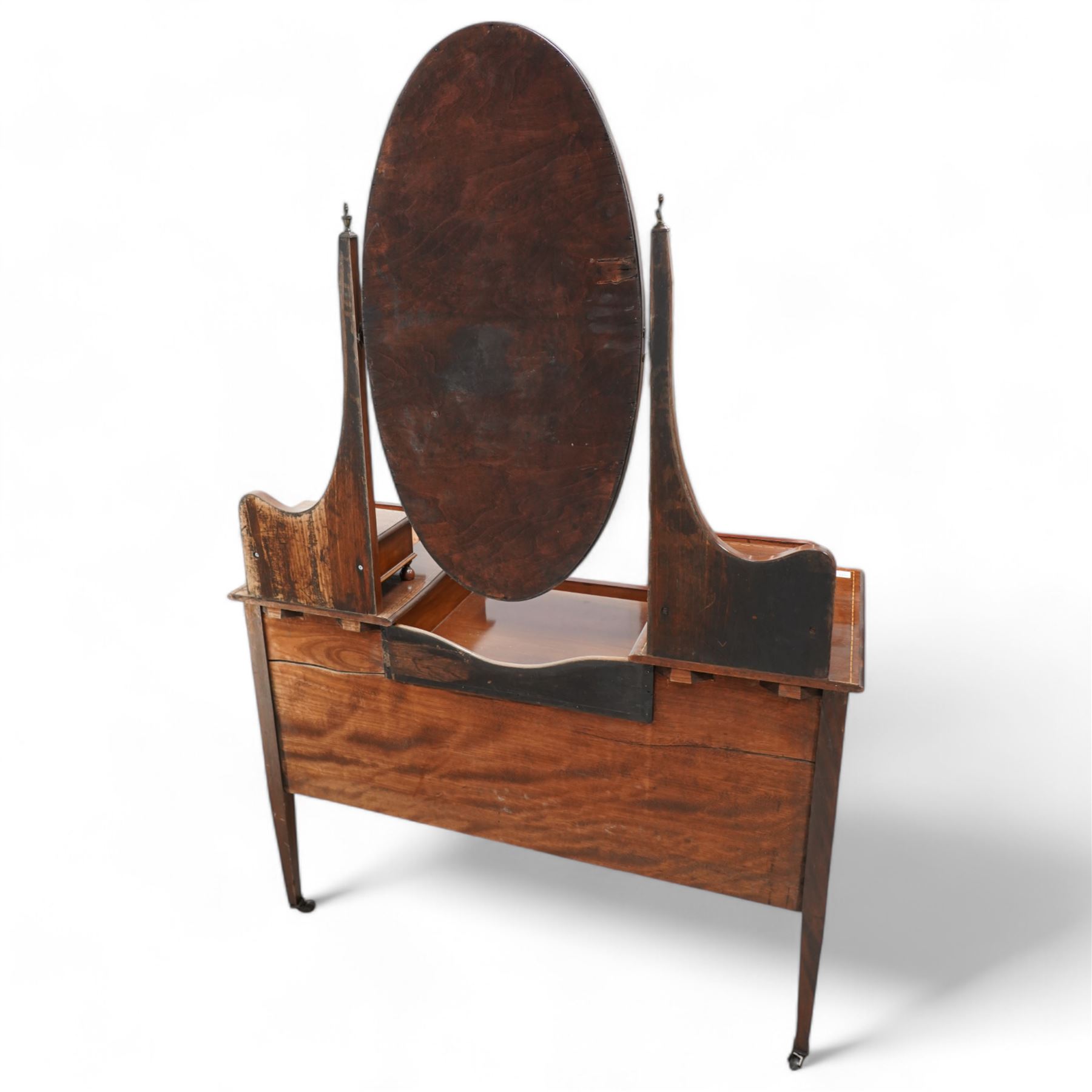 Edwardian inlaid mahogany drop-centre dressing table, bevelled oval swing mirror over trinket drawers, fitted with two short and two long drawers, on square tapering supports with brass castors