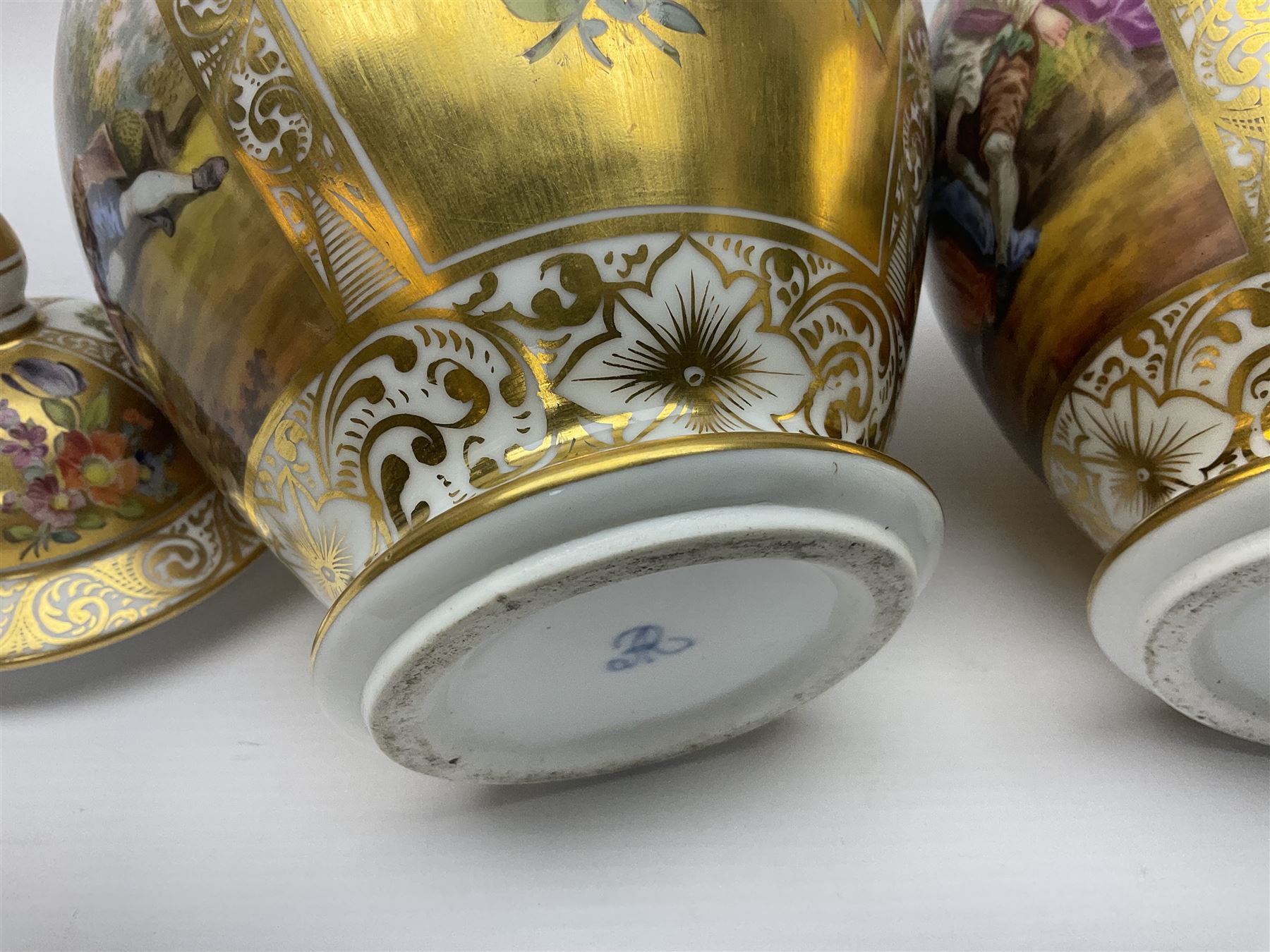 Pair of late 19th century Helena Wolfsohn vases and covers, each of baluster form with domed cover, painted with alternating panels of romantic scenes and floral sprays upon gilt ground, with Augustus Rex mark to base, H27cm