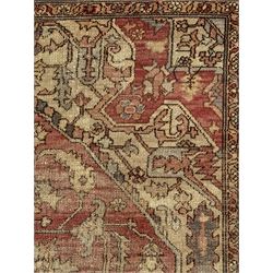 Persian Heriz design rug with red ground, the field featuring a central medallion with floral and geometric motifs, surrounded by ivory spandrels, the main border showcasing a series of floral patterns on a dark blue ground