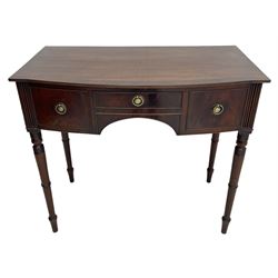 George III mahogany kneehole dressing or writing table, stepped bow-front form, reed moulded top with mahogany crossband, fitted with three cock-beaded drawers with circular pressed brass handle plates decorated with urn and beaded ring handle, on ring turned supports 