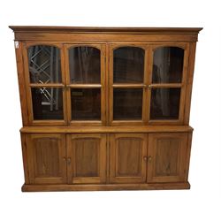 Mid-to-late 20th century Burmese teak wall cabinet, four glazed doors over four panelled doors, on moulded plinth base 