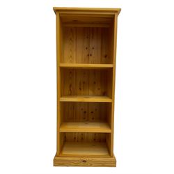 Narrow pine open bookcase, rectangular top over three shelves, on plinth base