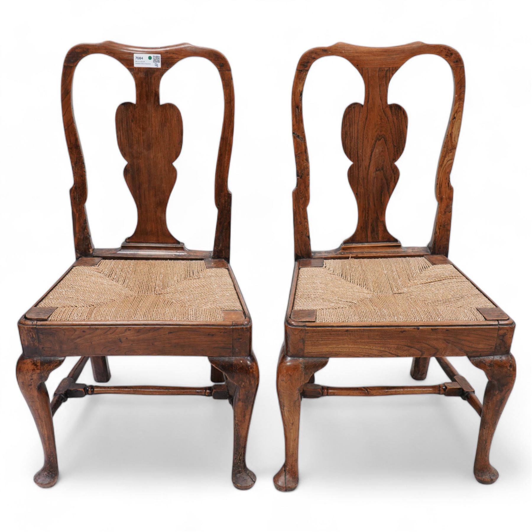 Pair of 18th century elm side chairs, shaped splat back over drop-in rush seat, on cabriole supports united by turned stretchers 