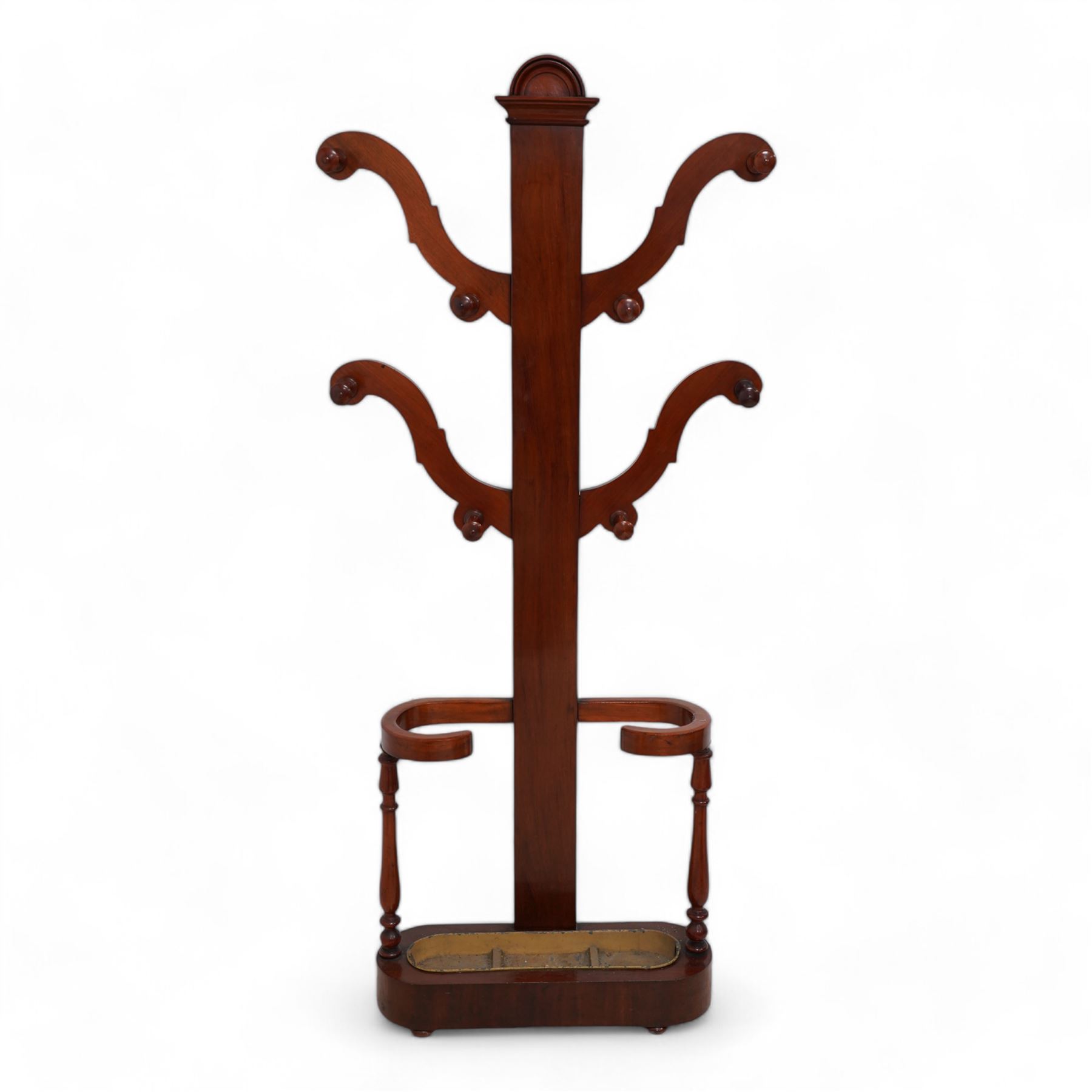 Victorian mahogany hall stand, central rectangular pillar supporting four projecting branches with turned hat and coat hooks, lower stick and umbrella stand on turned supports with metal drip tray, skirted base on compressed bun feet 