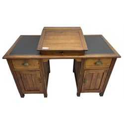 Edwardian pitch pine desk, rectangular top with writing slope flanked by inset leather writing surfaces, over twin pedestals each with shell cup handled drawer over cupboard, the left enclosing two shelves, the right enclosing sliding trays, on fluted straight supports