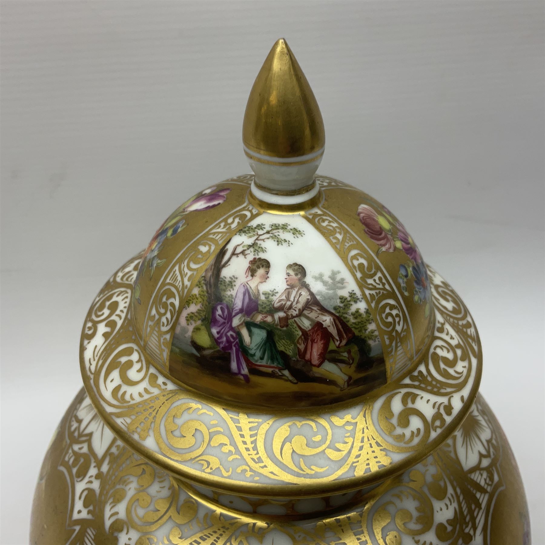 Pair of late 19th century Helena Wolfsohn vases and covers, each of baluster form with domed cover, painted with alternating panels of romantic scenes and floral sprays upon gilt ground, with Augustus Rex mark to base, H27cm