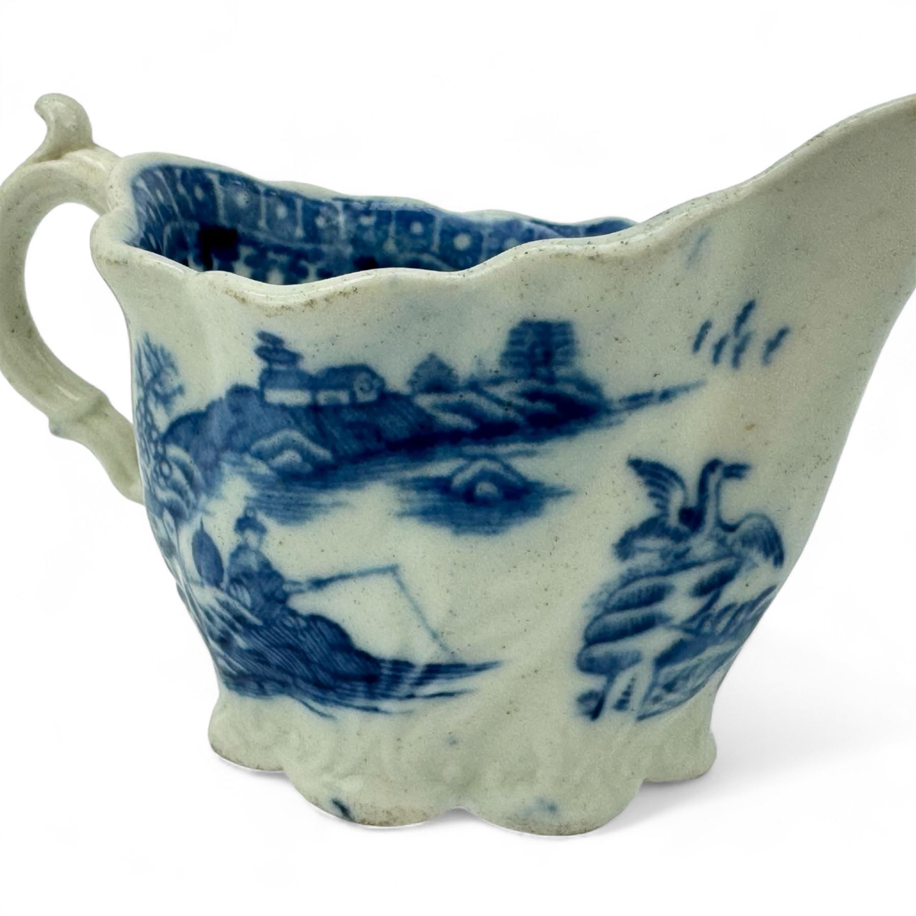 Caughley cream boat of Chelsea ewer form, L11cm and a Caughley leaf-form butter boat moulded on the underside with three leaves, L7cm, both printed in the 'Fisherman' pattern (2)