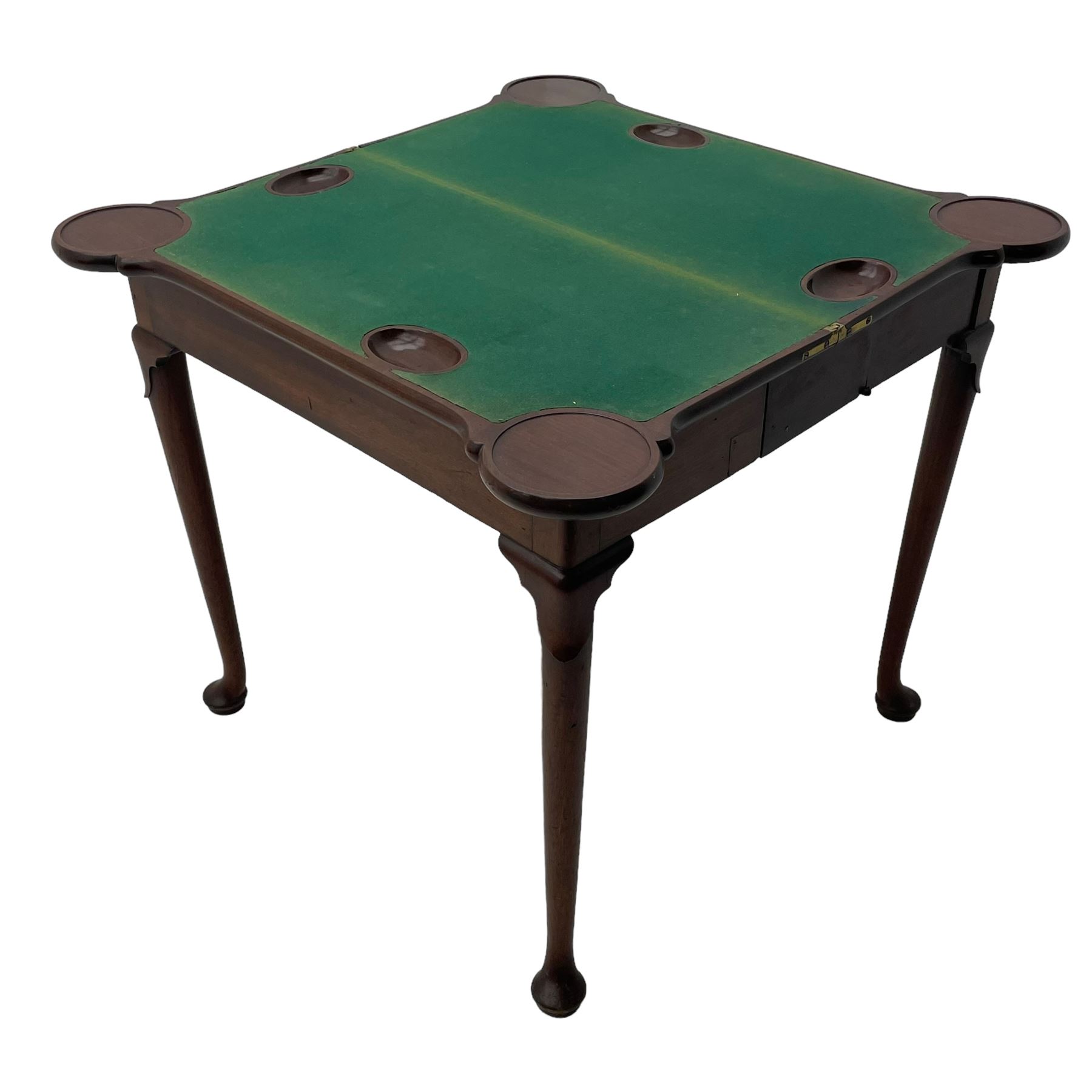 George III mahogany games table, the rectangular fold-over top with extending stepped rounded corners, opening to reveal baize lined interior with sunken counter wells, concertina action base, on lappet cabriole supports