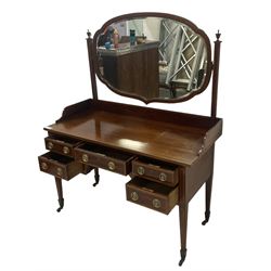 Edwardian inlaid mahogany kneehole dressing table, raised shaped oval bevelled mirror back, fitted with five drawers with banding and stringing, on square tapering supports with castors