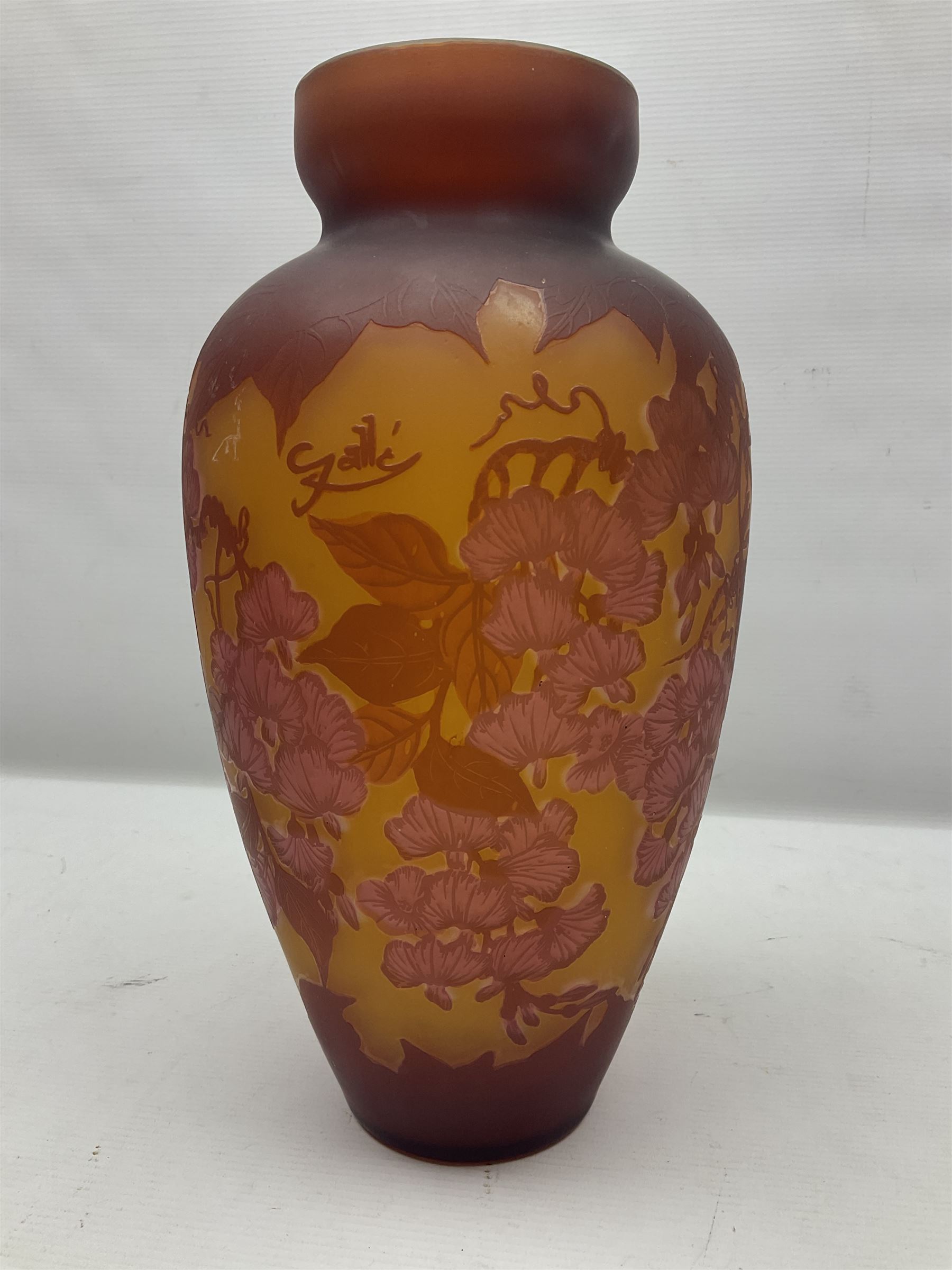 Art Nouveau style glass vase, in the style of Galle, the tapering body decorated with trailing red and pink foliage on a yellow ground, H33cm