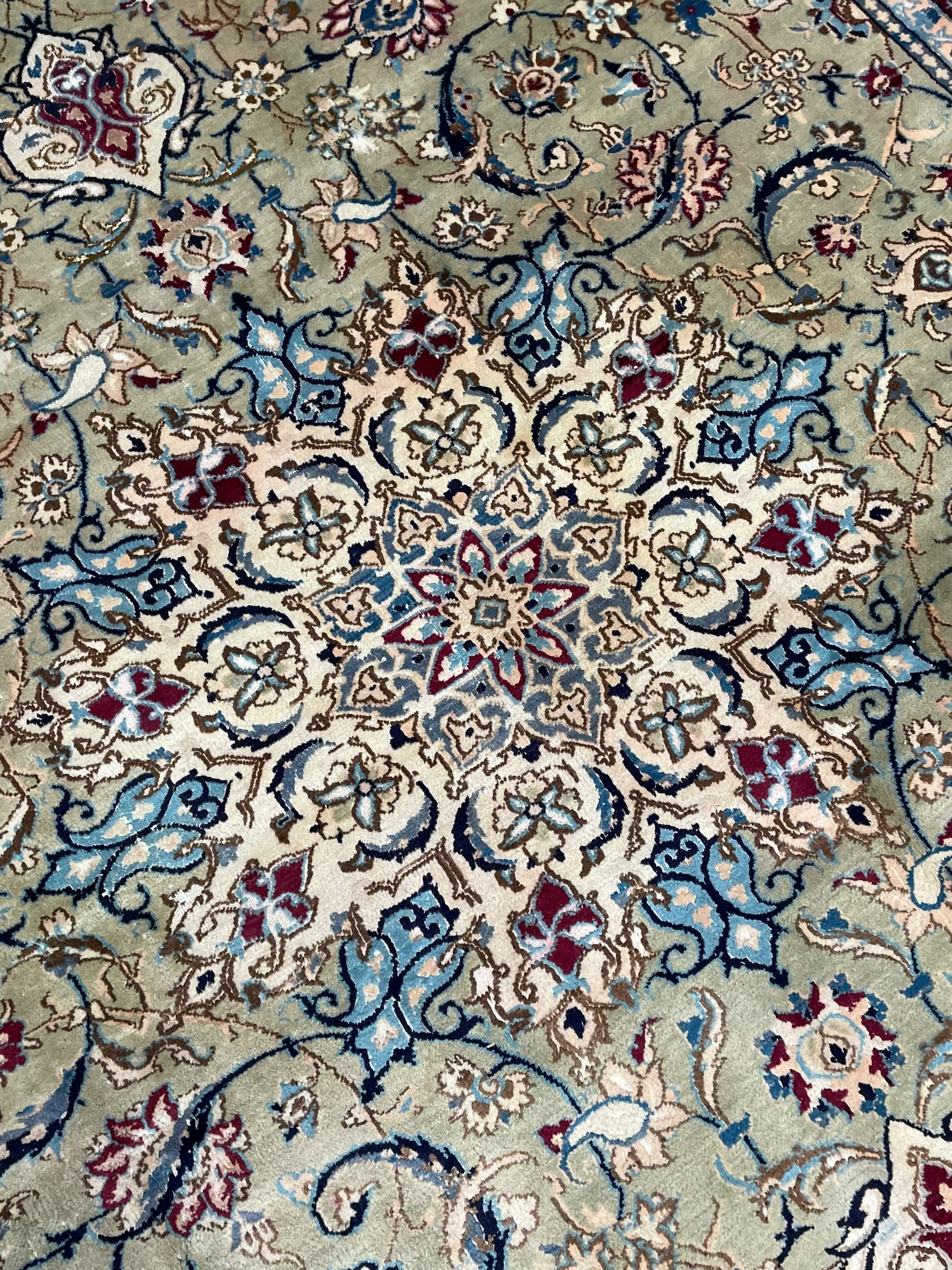 Persian Kashan olive ground carpet, central rosette medallion surrounded by swirling leafy branches and palmettes, the spandrels decorated with further palmettes and foliate motifs, scrolling border interspersed with stylised plant motifs, with in guard stripes