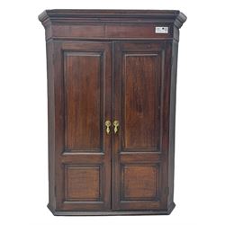 George III oak and mahogany corner cupboard, moulded cornice over mahogany frieze, enclose...