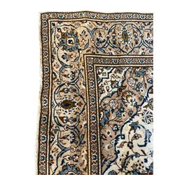 Persian Kashan ivory ground rug, the field decorated with interlacing branches and palmettes, central floral design pole medallion, the scrolling border decorated with stylised plant motifs, within repeating flower head guard stripes