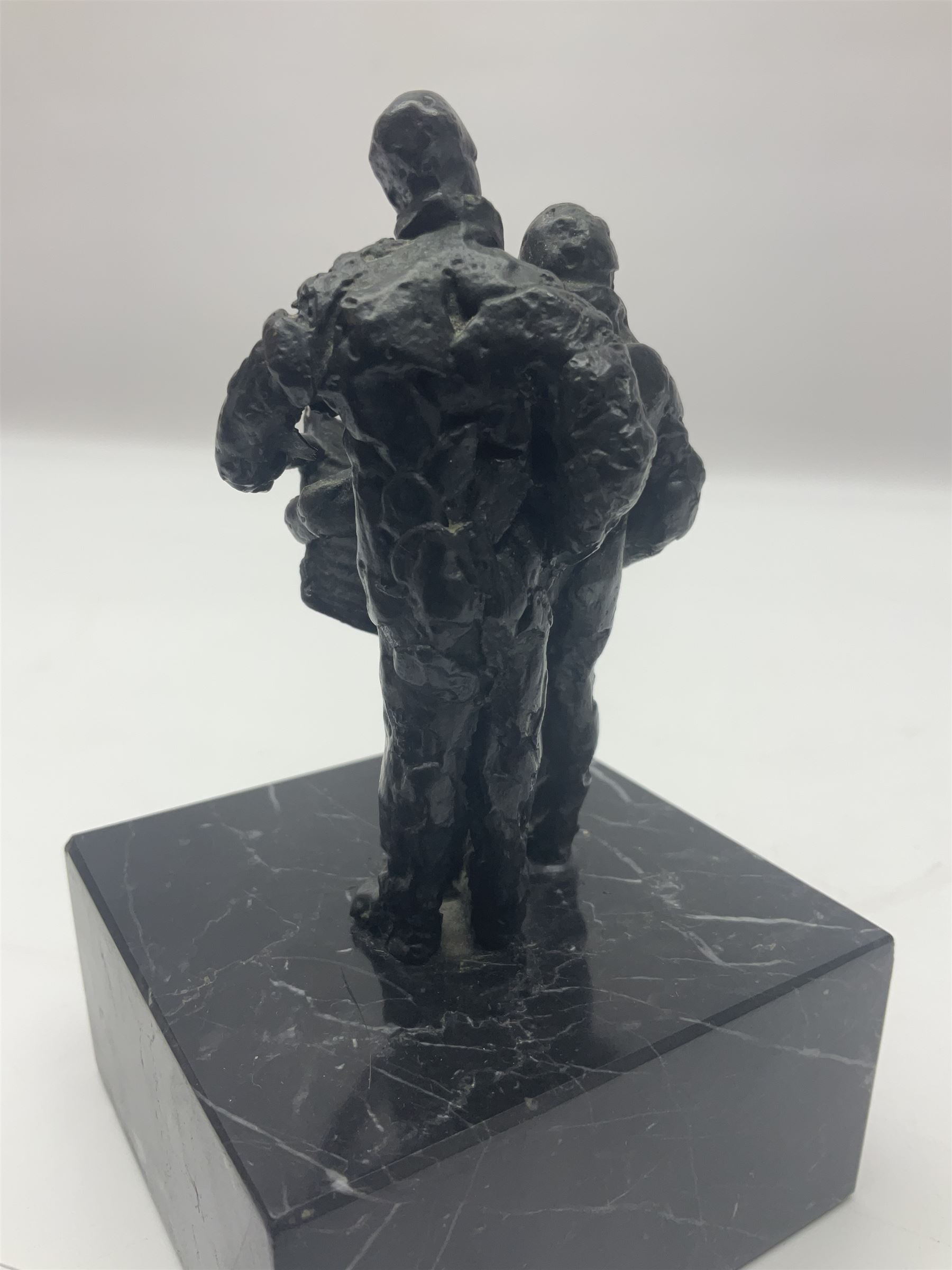 20th century bronze sculpture, modelled as two figures reading, upon a black and white marble base, H14cm