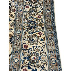 Persian ivory ground carpet, overall floral pattern with central rosette medallion, the field decorated with interlaced leafy branches and stylised plant motifs, guarded repeating border with repeating design