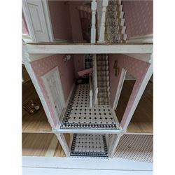 Large three storey modern dolls house, painted white with latticed windows, grey roof and metal fencing, with decorated interior, together with two dolls house garden rooms and two conservatories