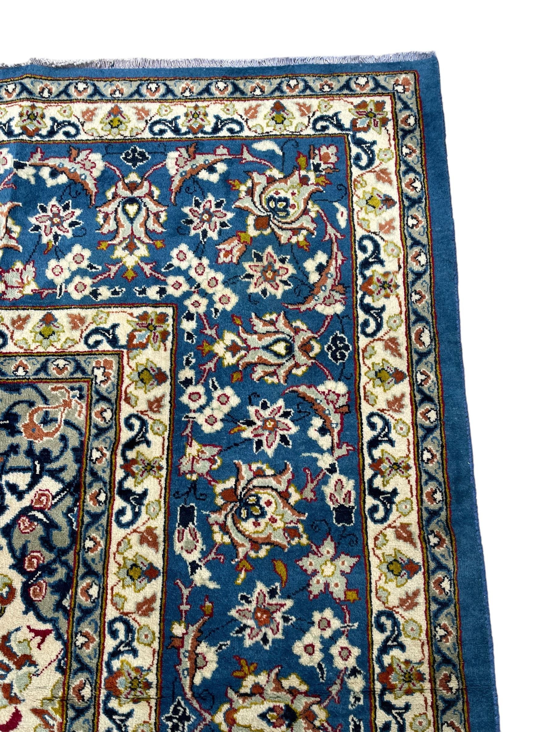 Persian Nain blue ground carpet, overall arabesque design, centre rosette medallion with eight projecting palmettes, the surrounding field decorated with interlacing branches and stylised plant motifs, within floral pale ground spandrels, the guarded border decorated with repeating stylised floral pattern 