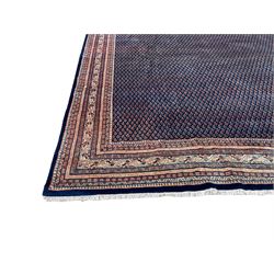 Large North-West Persian Arrak indigo ground carpet, the field decorated all-over with small Boteh motifs, multiple band border decorated with repeating geometric designs