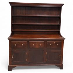 Late 18th century oak dresser, moulded cornice over three-tier plate rack, the base fitted with three drawers and two cupboards, enclosed by two panelled doors, on bracket feet, bone lozenge escutcheons 