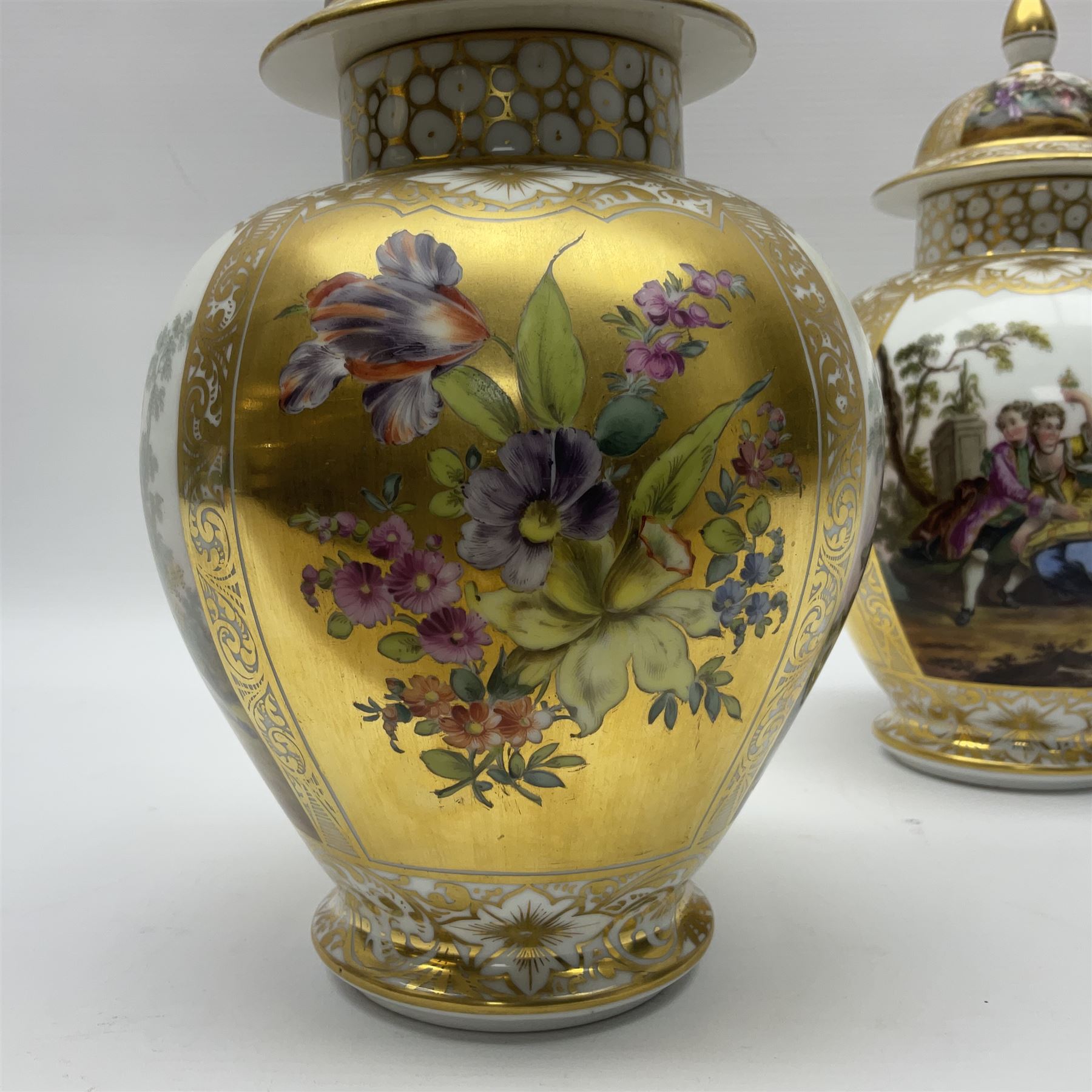 Pair of late 19th century Helena Wolfsohn vases and covers, each of baluster form with domed cover, painted with alternating panels of romantic scenes and floral sprays upon gilt ground, with Augustus Rex mark to base, H27cm