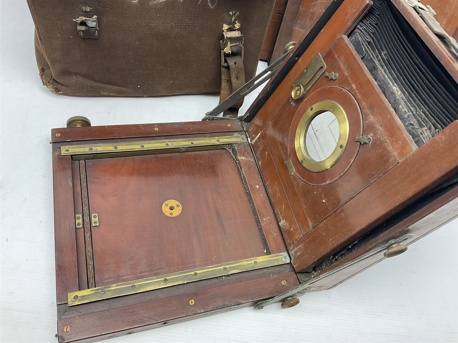 Folding plate camera in mahogany and lacquered brass, with additional plates and case