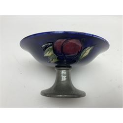 Moorcroft small pedestal dish decorated in the Wisteria pattern against a dark blue ground raised to a Tudric pewter stand, impressed beneath Tudric, Moorcroft, H9cm