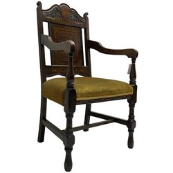 Late 19th to early 20th century oak elbow chair, the shaped cresting rail carved with scrolls and foliage, panelled back inlaid with parquetry work and central rampant lion within shield, upholstered seat, on turned supports joined by H stretchers