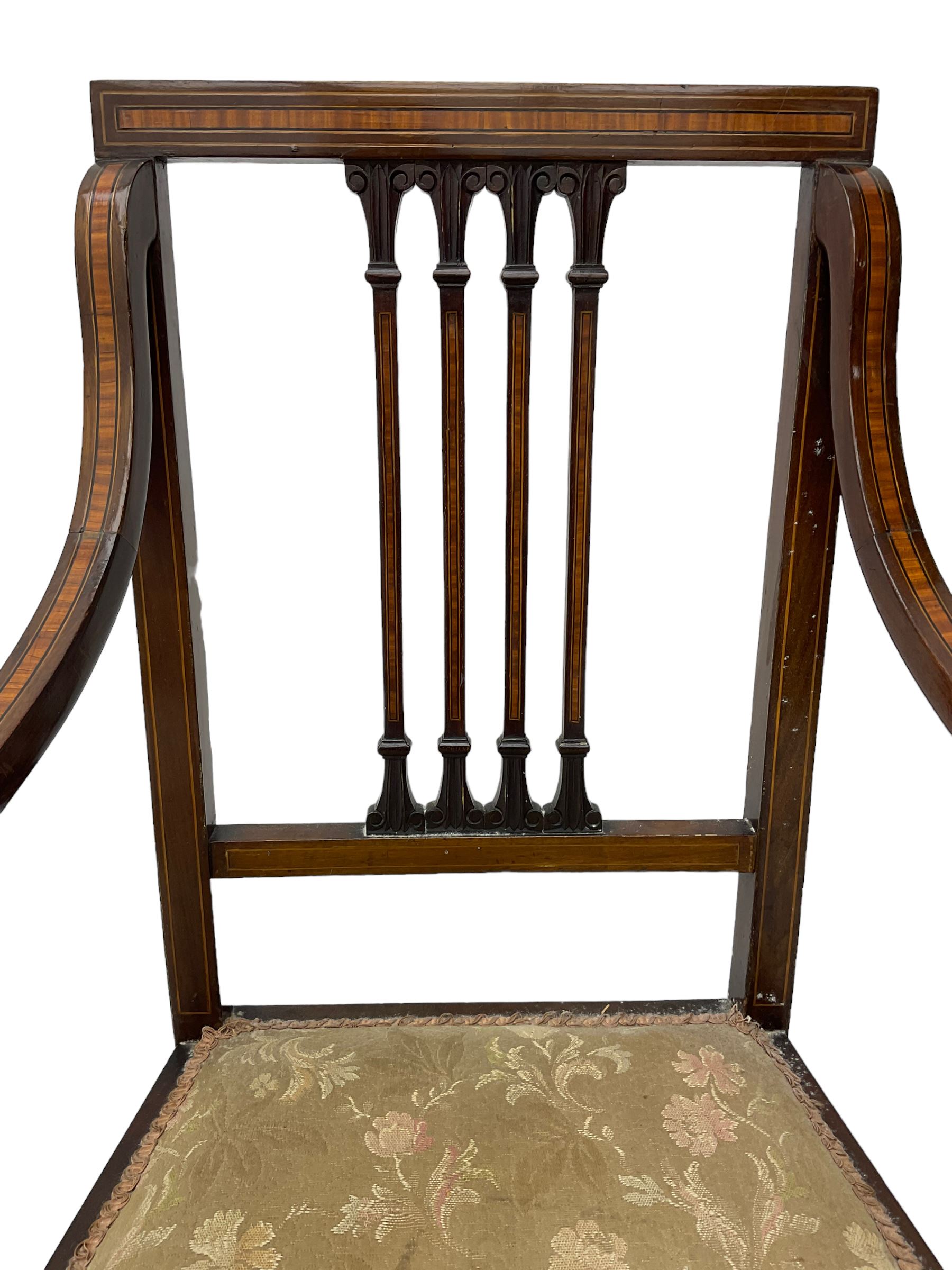 Edwardian satinwood inlaid mahogany elbow chair, the bar back over four vertical rails with foliate and scroll carved decoration, curved and down-swept arms, on square tapering supports united by stretchers 