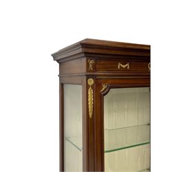 Early 20th century Louis XVI design mahogany vitrine display cabinet, projecting stepped cornice over recessed frieze decorated with gilt metal mounts of festoons and a bellflower wreath, fabric lined interior with two glass shelves, enclosed by bevel glazed door with lower panel, on two turned front feet 