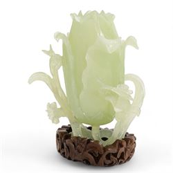 Chinese green jade magnolia form vase, supported on a leafy stem, with flowers and butterflies, on a pierced and carved hardwood stand, H15cm x W14cm