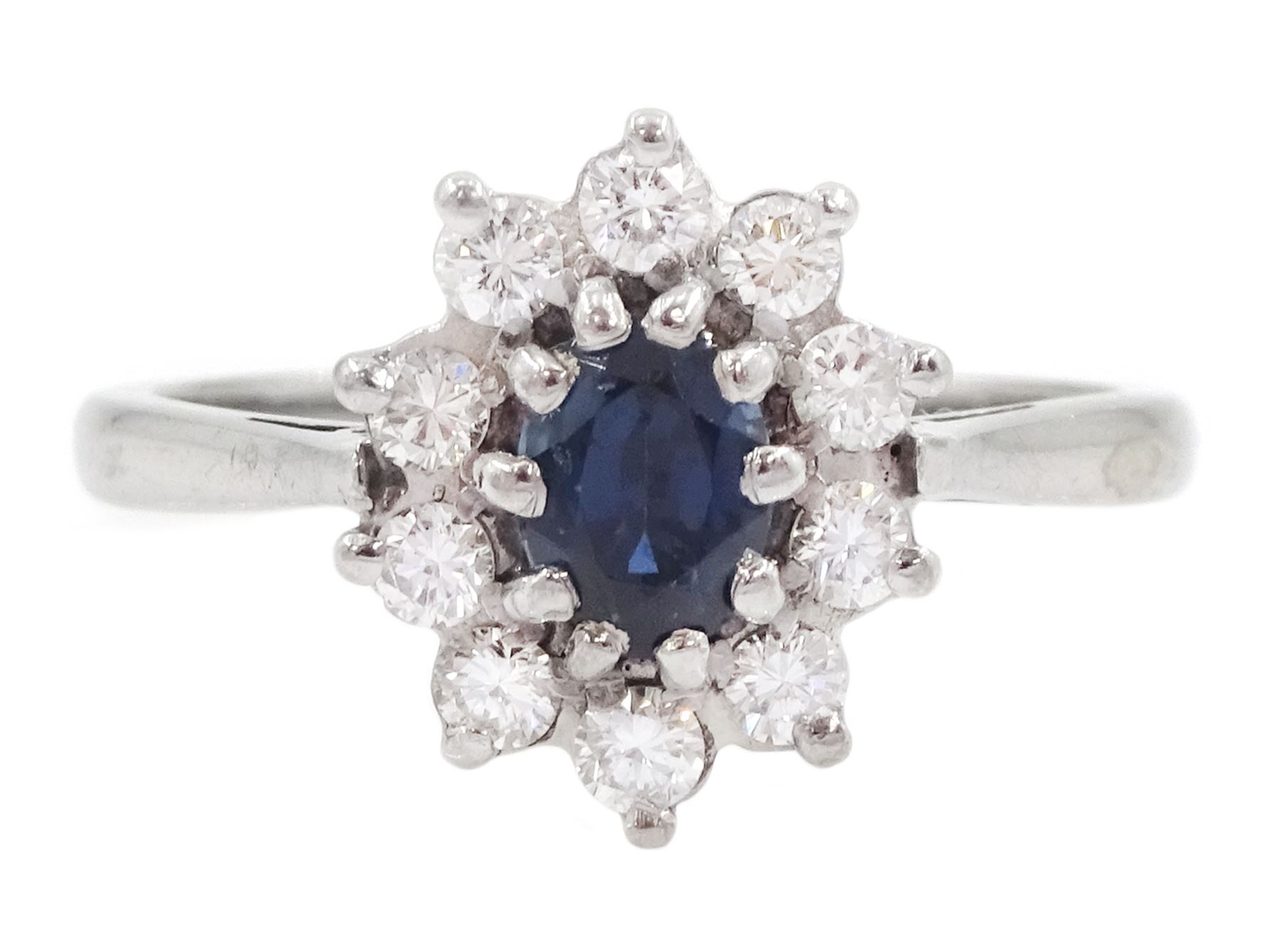 18ct white gold oval cut sapphire and round brilliant cut diamond cluster ring, London 1973, sapphire approx 0.50 carat, total diamond weight approx 0.30 carat 