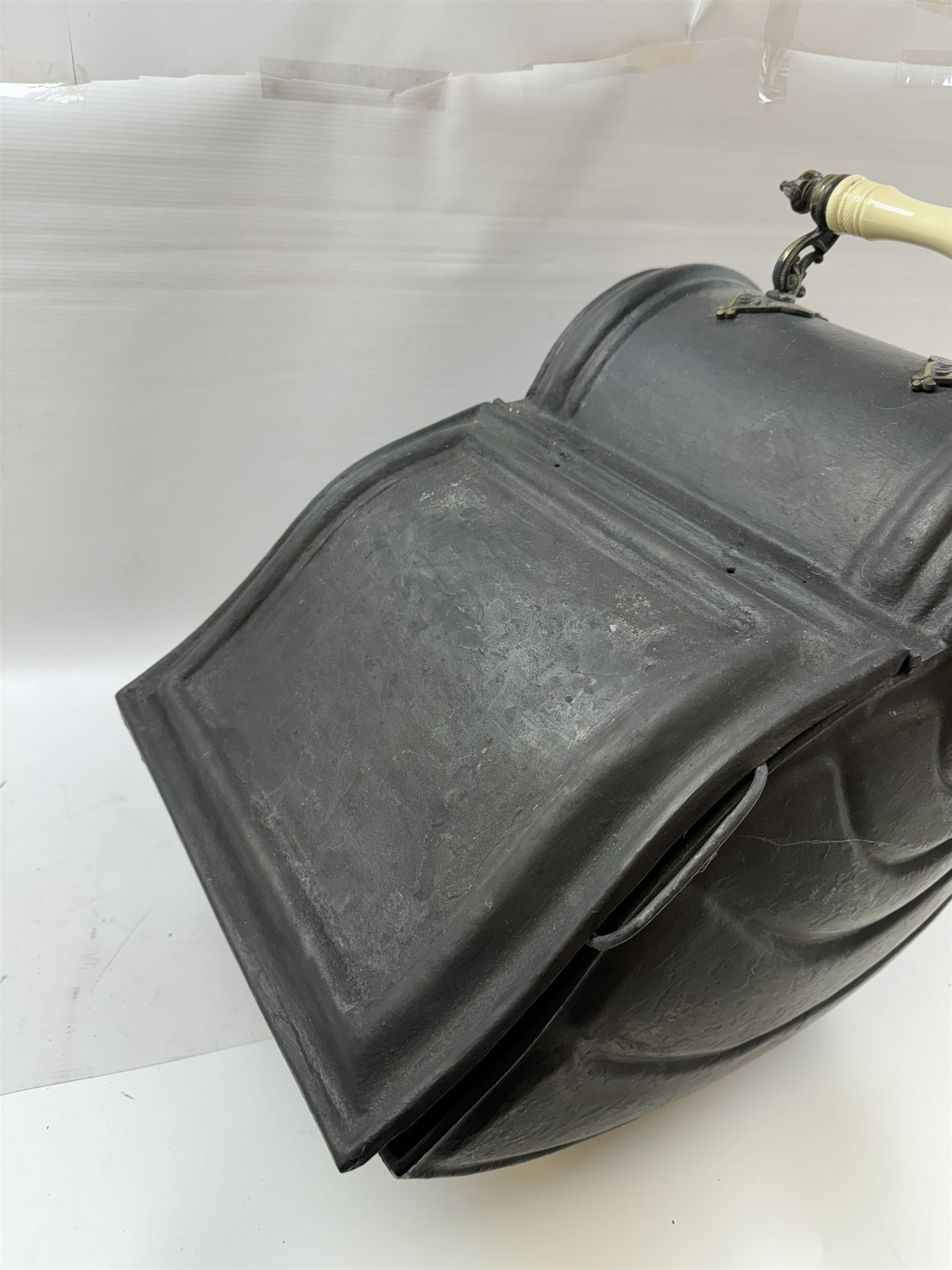 Victorian black matte metal coal scuttle, in the form of a nautilus shell, with ceramic wheels and handle, H47cm