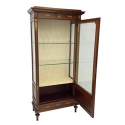 Early 20th century Louis XVI design mahogany vitrine display cabinet, projecting stepped cornice over recessed frieze decorated with gilt metal mounts of festoons and a bellflower wreath, fabric lined interior with two glass shelves, enclosed by bevel glazed door with lower panel, on two turned front feet 