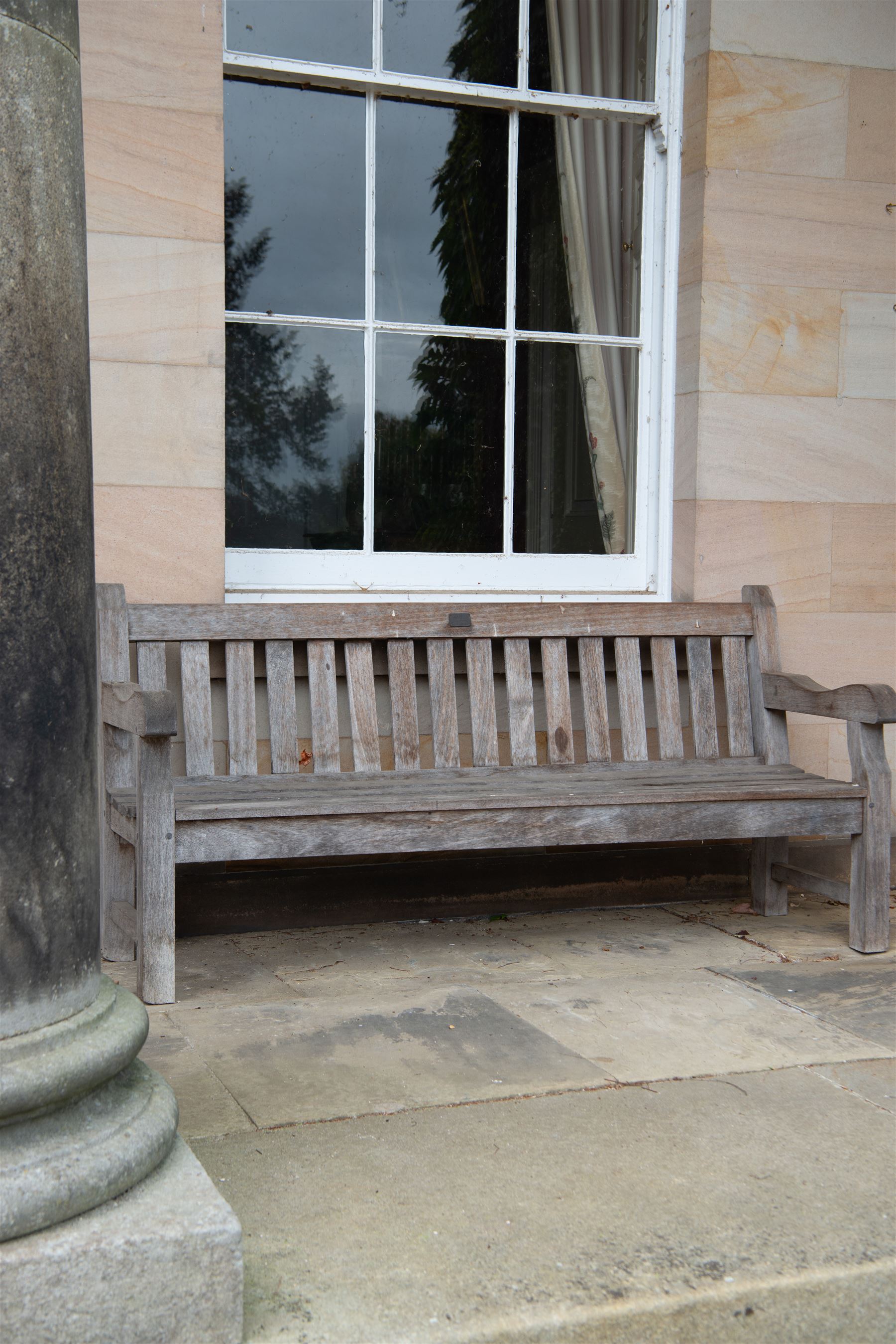 'J.V.T. Ampleforth' - teak garden bench, plain cresting rail with applied maker's plaque over slatted back and seat, on square supports 