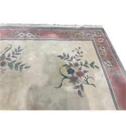 Chinese ivory ground washed woollen carpet, the field decorated with five large floral motifs with extending leafage, the wide rose guard band decorated with further floral patterns