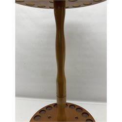 Pine stick stand, with turned central column dividing two circular tiers, upon three feet, with capacity for twenty four walking sticks, H73cm