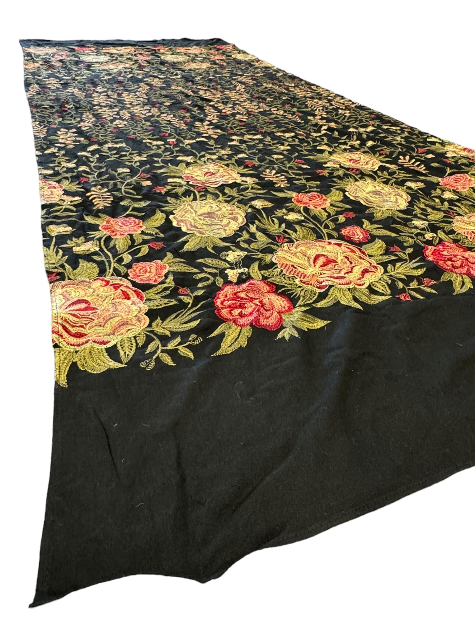 Embroidered Karandi fabric runner, the field featuring a black ground with an all-over floral design, including large pink and cream roses, accompanied by green leaves and small blossoms, bordered by plain sections at each end