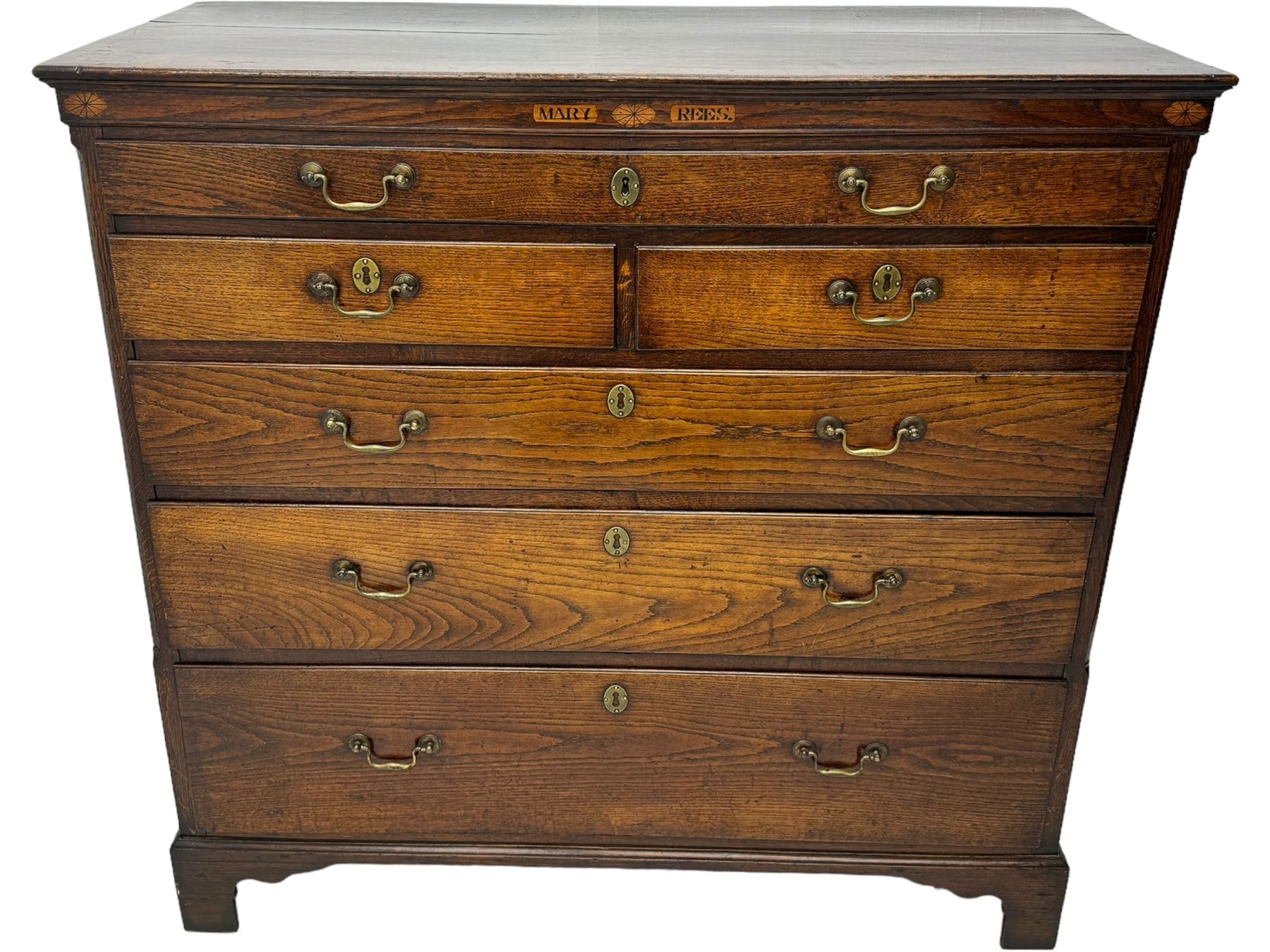 George III oak chest, rectangular top over frieze with inlaid with inscription panels 'Mary Rees' and fan motifs, frieze drawer over two short and three long graduating drawers, fitted with brass swan-neck handles and oval escutcheons, on bracket feet