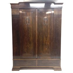 Early to mid 20th century oak double wardrobe, the interior fitted with hanging space and shelves, two drawers to base, shaped bracket feet