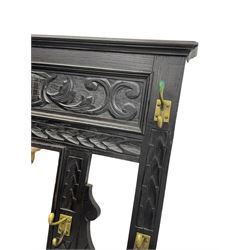 Victorian oak hall stand, the upper section featuring eight brass hooks and central mirror plate flanked by scroll-carved panels, the central section includes a storage box positioned above an umbrella stand, supported by square carved legs with scroll-carved horizontal supports