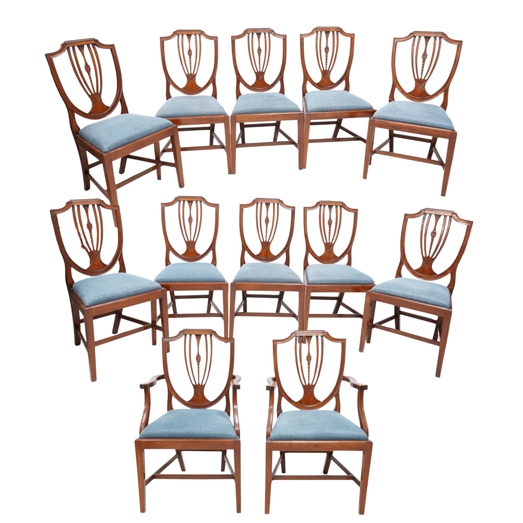 Set of twelve (10+2) Hepplewhite Revival mahogany dining chairs, moulded shield back with satinwood band, drop-in seat upholstered by Peter Silk of Helmsley, on square tapering supports united by H-stretchers 