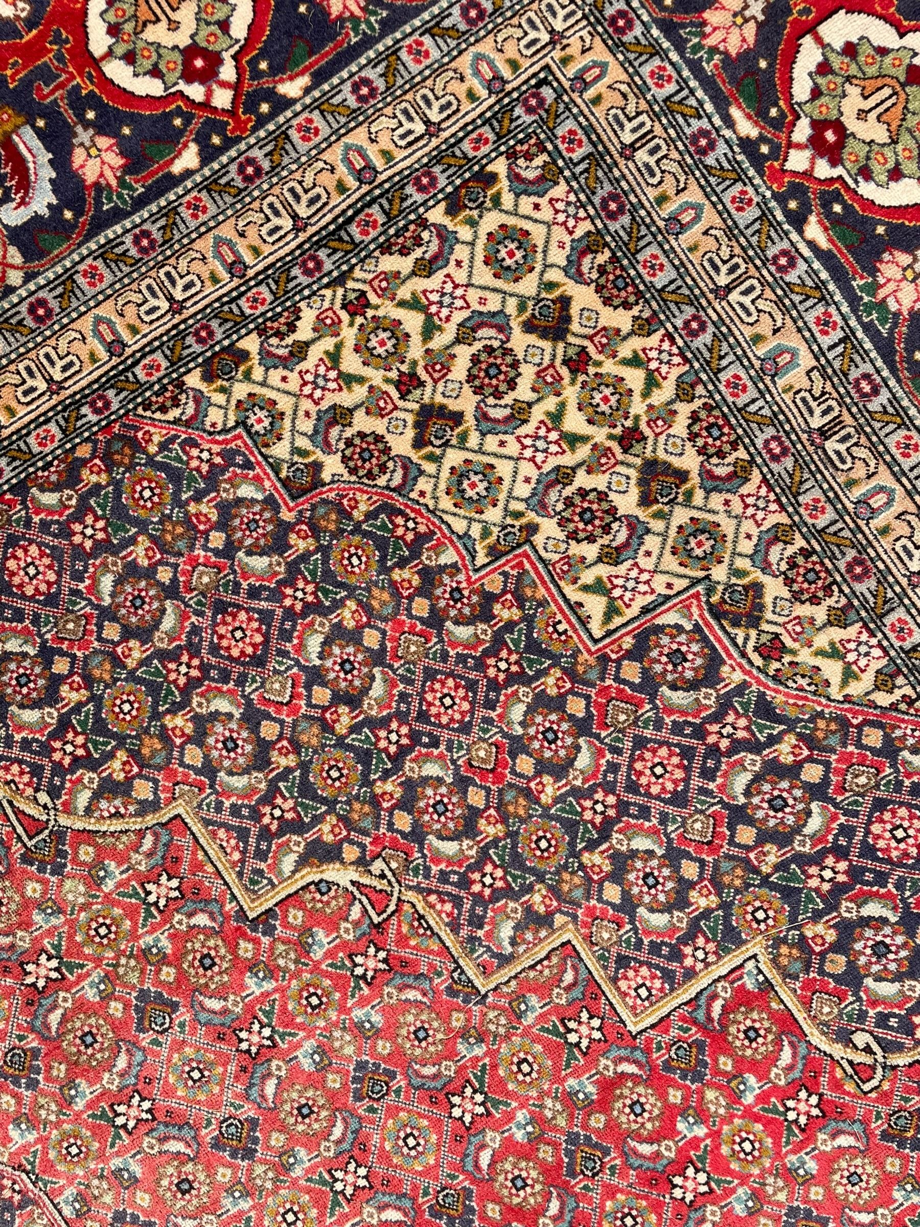 Perisian Bidjar crimson ground rug, within scalloped borders, central pole medallion, the field decorated all over with floral Herati motifs, guarded border decorated with repeating stylised plant motifs and trailing branch 