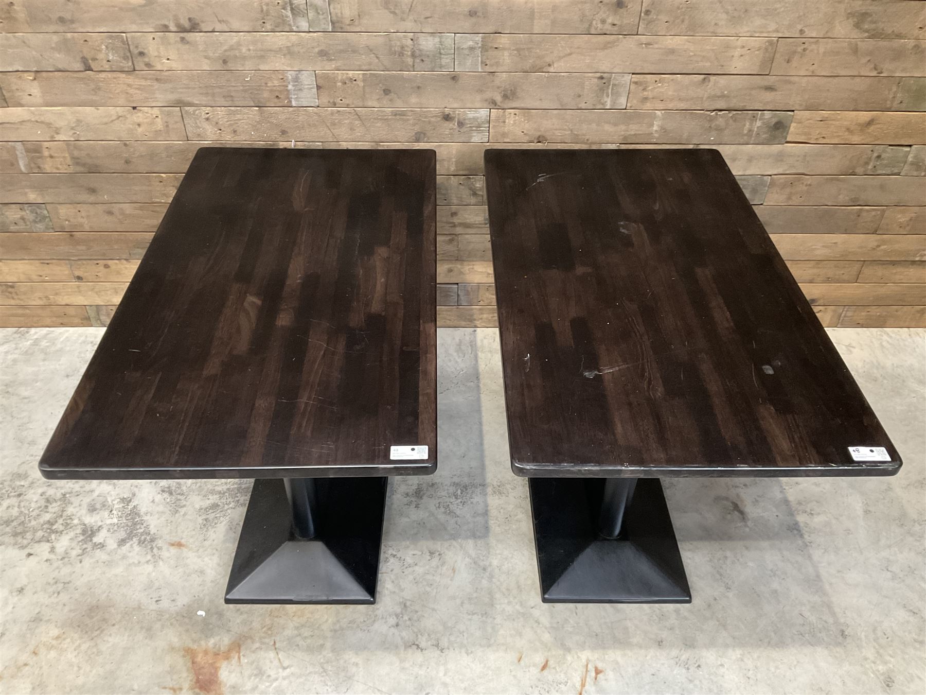 Two dark walnut rectangular console tables, on black metal bases