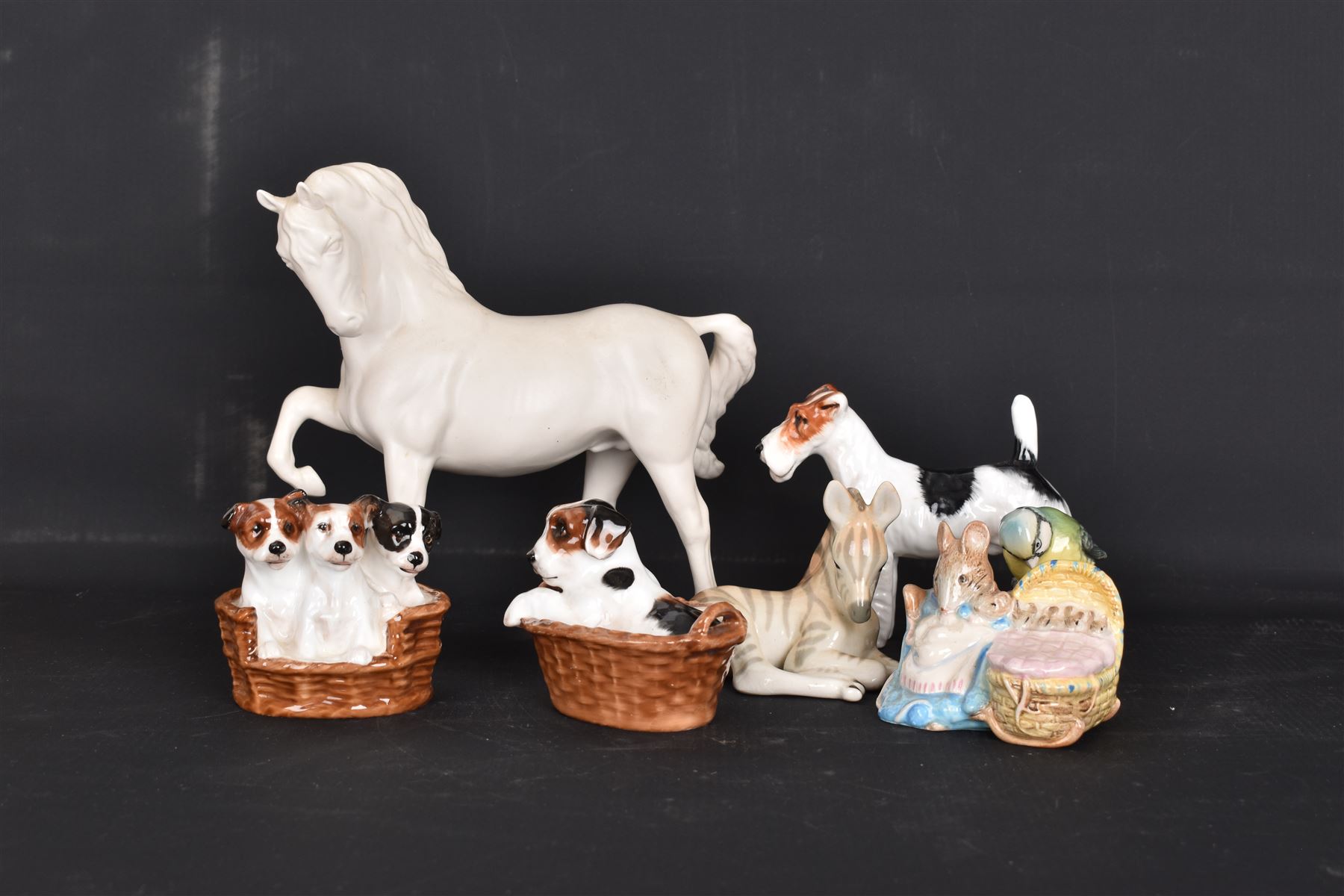 Two Royal Doulton figures of puppies in baskets, together with Beswick horse and other animal figures