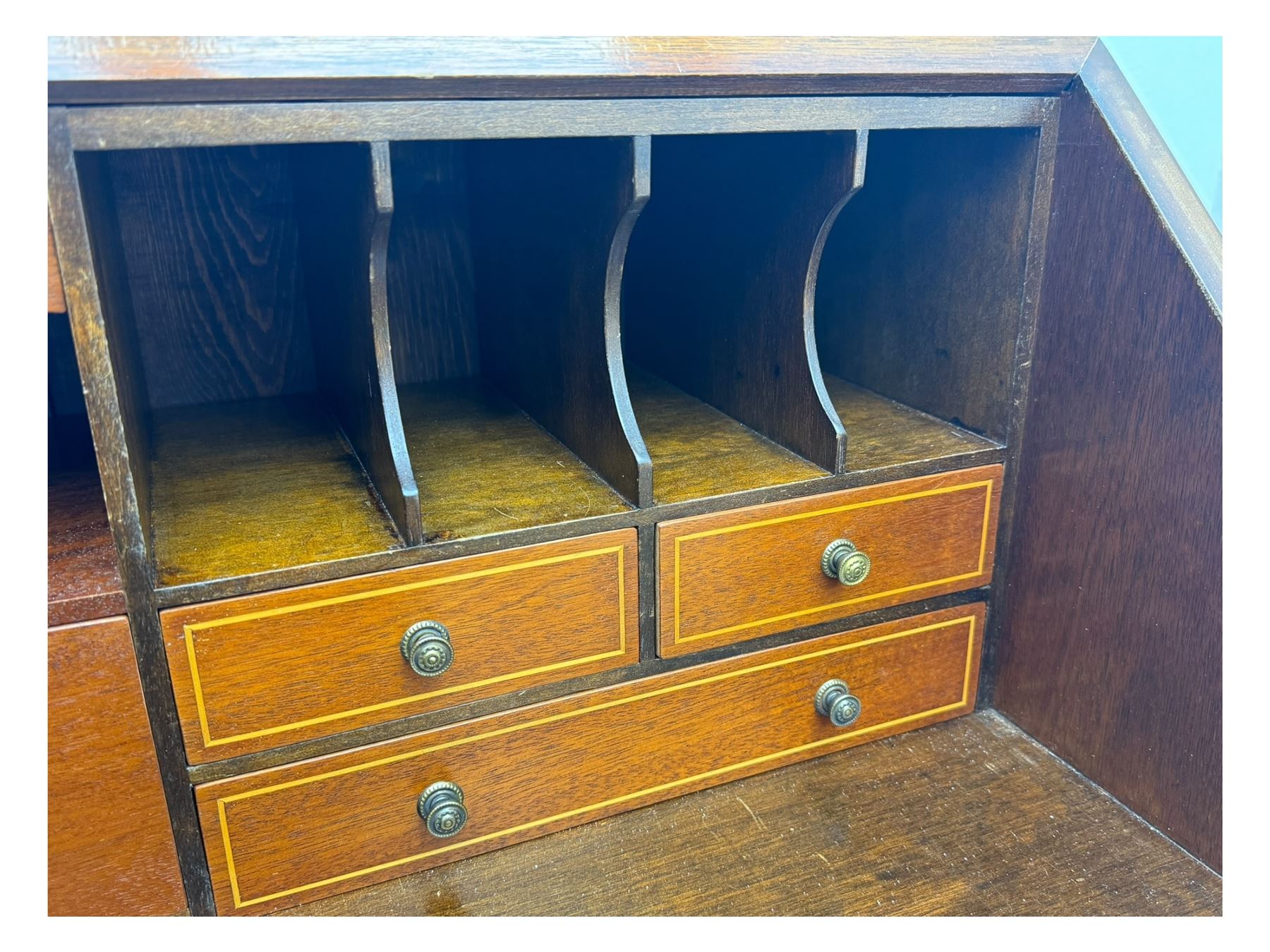 Mid-to-late 20th century inlaid mahogany bureau, inlaid floral medallion to the top, the fall front opening to reveal fitted interior with pigeonholes, small drawers and central cupboard, green inset writing surface with gilt tooling, four drawers below with brass handles, raised on shaped bracket feet