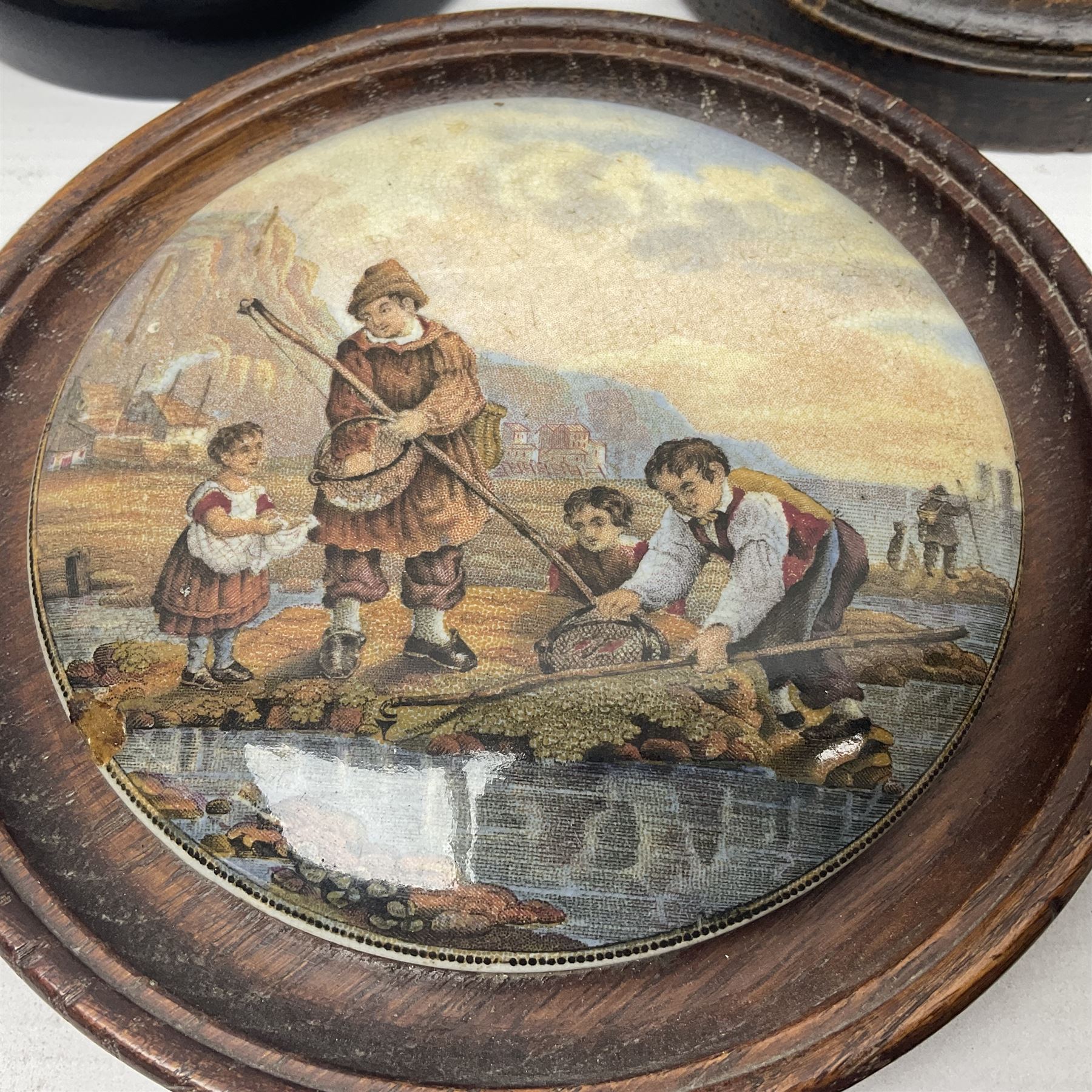 Six framed Prattware pot lids comprising 'Bear, Cock & Lion', 'Bear on Rock', 'Alas! Poor Bruin', ' Lady, Boy and Goats', 'The Shrimpers' and one other, largest D15.5cm (6)