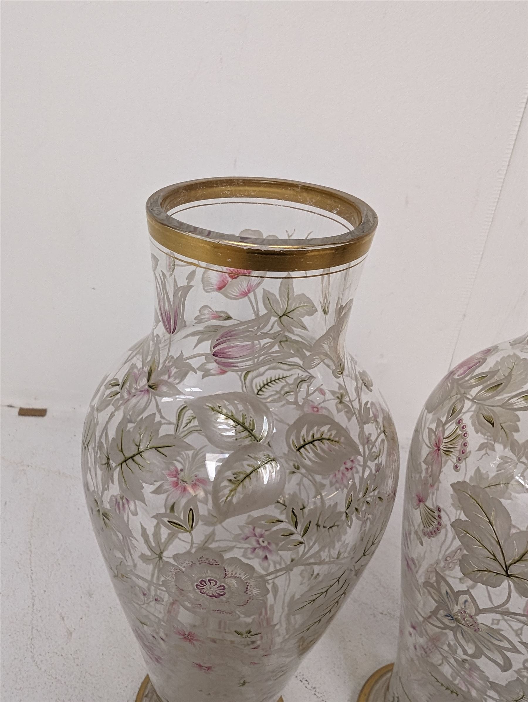 Pair of glass vases, of baluster form, painted with floral and foliate decoration, with gilt base and rim, H27.8cm